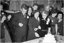 Newlyweds cutting their cake at a modest wedding ceremony, typical of the World World II era, Georgia, 1939