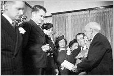Justice of the Peace reading from a book, at a modest wedding ceremony at bride's home, typical of the World World II era, Georgia, 1939