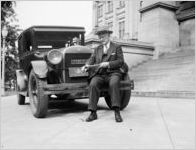 Judge Samuel C. Attinson sitting on the front bumper of a Springhill automobile widdling