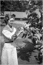 Young woman holding a squirrel outdoors, Georgia, 1930s