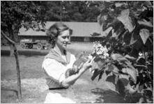 Young woman holding a squirrel outdoors, Georgia, 1930s