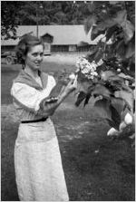 Young woman holding a squirrel outdoors, Georgia, 1930s