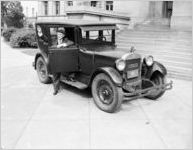 Judge Samuel C. Attinson in the passenger seat of a Springhill automobile waving