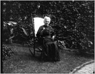 Elderly woman sitting in a rocking chair in a garden, Atlanta, Georgia