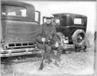 Hunter sitting on the back bumper of a car, Georgia, 1931