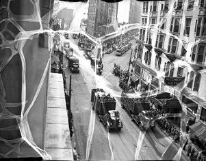 View of cars proceeding down Peachtree Street with crowds lining streets during Armistice Day Parade, Atlanta, Georgia, 1940