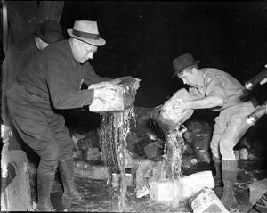 Revenuers destroying illicit whiskey still during Prohibition, 1930s