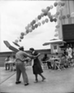 African American man and woman dancing during a roof top party, 1950s