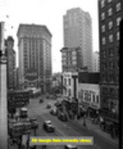 View of Peachtree Street looking towards Margaret Mitchell Square and the large Coca-Cola billboard. Shot made from upper floor of a building, looking down. On the right is Chandler's Shoes and on the left is a sign for Frances Virginia Tea Room, Atlanta, Georgia, August 10, 1953.