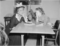 Anita Colby (left) with child, speaking into a radio microphone labled "WBGE ",Atlanta, Georgia, May 11, 1948