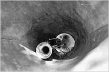 Looking down the inside of a megaphone towards a trumpet a young boy is playing, Georgia, July 1937.