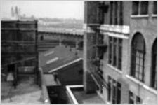Atlanta rooftops, back of a billboard, elevated roadway over train tracks in middle ground, towers of the Terminal Station in background, Atlanta, Georgia, September 1937