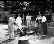 Celebration with speeches and barbecue at the American Thread Company, Tallapoosa, Georgia, January 28, 1944. In this photo, five men are boiling foodin cast iron pots or kettles, over an open fire