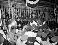 Speech being given over WRG radio at the Army Navy "E" Award ceremony, Anchor-Duck Mills, Rome, Georgia, February 1944. A military band is in the foreground