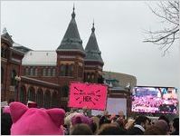 Protesters in front of a television monitor showing speakers at the march, Women's March on Washington, 2017-01-21