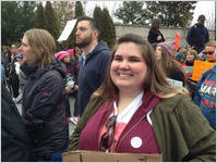 Close-up of protester smiling and wearing Nasty Woman sticker, Women's March on Washington, 2017-01-21