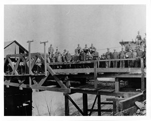 Group photograph of miners owner on bridge near tipple, circa 1890s