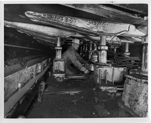 Miner activating movable hydraulic steel roof props in central Pennsylvania coal mine, 1970-02