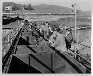 Miners standing alongside coal cars, circa 1960s
