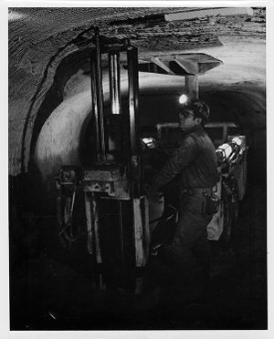 Roof bolter drilling holes for long expansion bolts which support the mine roof,1976