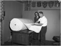 Examining a roll of Southern Mills fabric, 1963