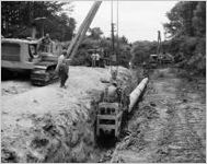 Construction workers installing pipe