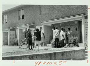 People gather in front of the home where a 4-year-old girl was killed, April 26, 1990