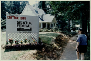 Colleen Boyles walks in front of a sign labeling the Durand Farm development as 'destruction', August 20, 1992