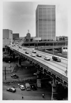 People walking to their cars under the Spring Street Viaduct, undated