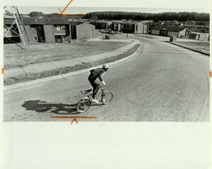 Atlanta Subsidized Housing, Boy Rides Bike Outside of Public Housing Project, January 8, 1984
