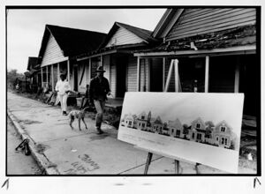 People walk in front of houses that are soon to be renovated, December 16, 1988