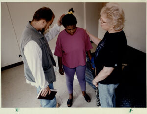 Dick Christensen and Betty O'Hara, two members of Blood-n-Fire Ministries praying for Sequia Gilstrap, a Capitol Homes resident, September 3, 1994