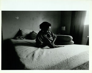 Linda Anderson, Former Drug User who Lives In Carver Homes, Sits, Reading, In One of the Two Bedrooms in Her Apartment