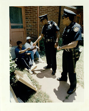 Officer R.L. Tellis Gives Carver Home Resident Debra Clark His Buisness Card, May 19, 1994