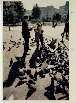 Dave Hetzel passes out a 'missing' flyer to a man feeding pigeons, April 27, 1991