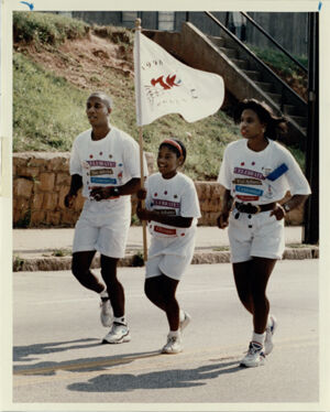 Afi Conwell (center) carries a '96 Games Flag Down Georgia Avenue, July 11, 1993