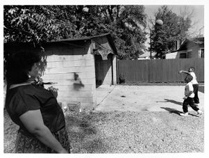 Sandra Jones watches as her son Brandon and nephew Brian Jones play basketball