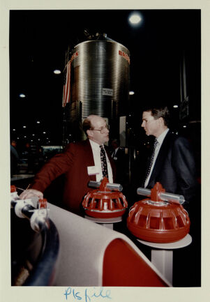 Rodney Carpenter (Left) and Chris Chocola (Right) Standing Near Feeders and a Silo in the Background at the Poultry Exposition at the World Congress Center, January 21, 1994