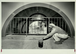 Tilbert Baynham paints the entranceway of the Edgewood Railcar Barn, March 8, 1987