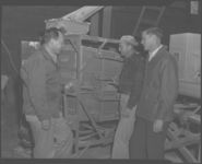 Ed and Roy Komarch and G.D. Branch Asst. County Agent at seed corn grader.