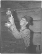 E. P. Ledford cleaning lantern. Bull Creek community just getting electricity