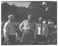Three men with turkeys in background