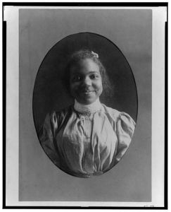 [Young African American woman, half-length portrait, facing front, smiling]