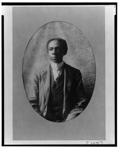 [African American man, half-length portrait, seated, facing slightly left]