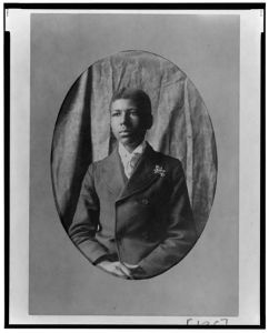 [Young African American man, half-length portrait, seated facing slightly left]