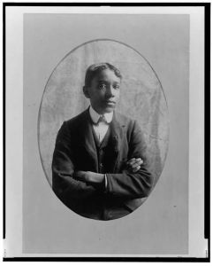 [Young African American man, half-length portrait, with arms crossed, facing front]