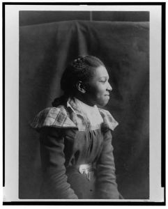 [African American woman, half-length portrait, seated, right profile]