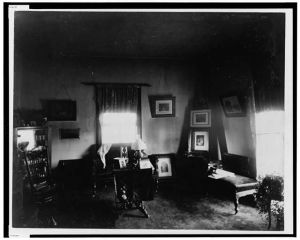 [Interior view of room showing furniture and framed pictures]