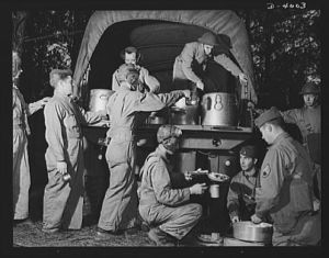 Fort Benning. Armored forces personnel. Names like "Hell Buggy" and "Wildcat" are painted on the helmut of these armored forces trainees lined up for chow at Fort Benning, Gerogia. As long as a soldier can eat and give disrespectful names to his equpment, he's going along alright