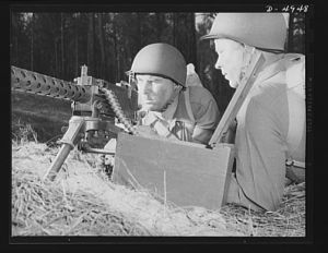 Fort Benning machine gunners. A couple of experts at slowing up the Axis timetable. These two members of a machine gun crew doing post-graduate work at Fort Benning, Georgia have a fast, accurate piece, and they know how to use it